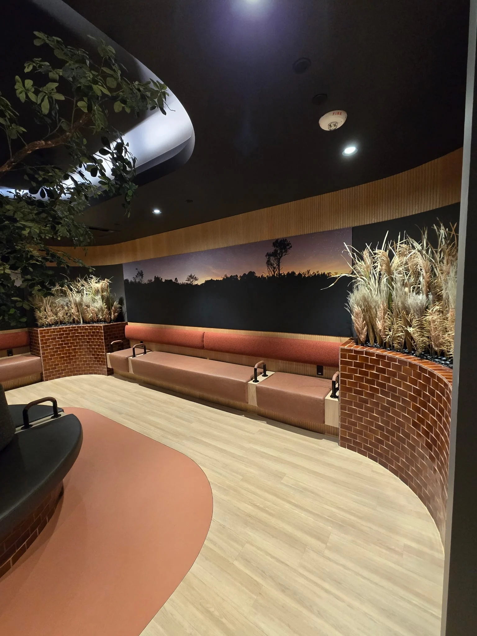 Dried pampas grass planters and faux branches in a dim resident lounge