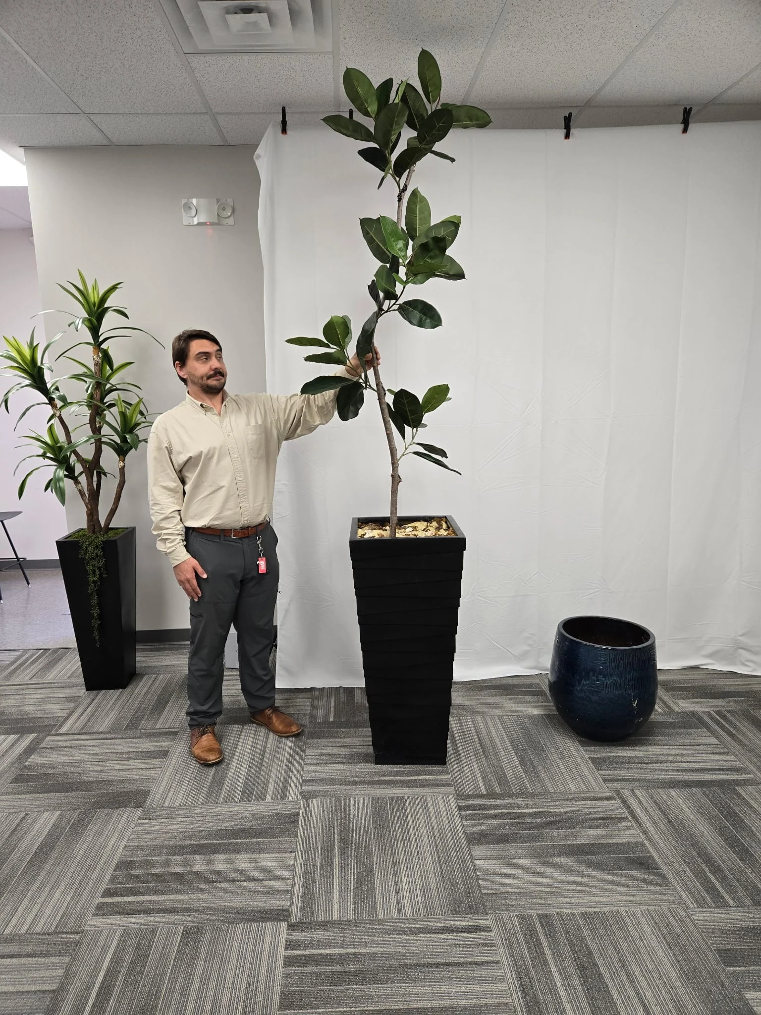 An Arboria Flora team member hand-shaping the branches of a large faux tree during fabrication